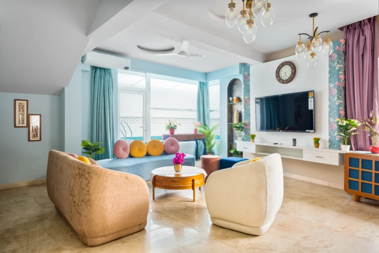 Celeste - Vio Stays - 3BHK Luxury Private Pool Villas In Baga - Living room/hall with television, 8-seater sofa, centre table, flower pot, paintings, window, curtains, & fan.