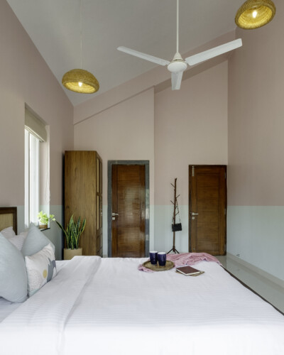 Ina - Villa in Siolim Goa - bedroom 2 of 4 - paintings, attached washroom, balcony with paddy field view, side table, mirror and dressing table, well light bedrooom